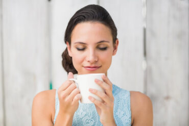 woman sipping tea before her ginseng skincare routine